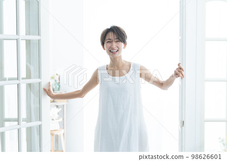 一個女人帶著微笑穿著白色的一件 一個女人帶著微笑穿著白色的一件 98626601