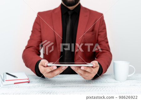 Businessman in Red jacket sitting at table and holding mobile phone. Presenting an important message. Executive In Suit Presenting Crutial Information. 98626922