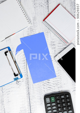 Color paper in shape of dialog box with important message. Infromation written on sticker. Different office stationery. Calculator, pencils, pens laing white table. 98626937