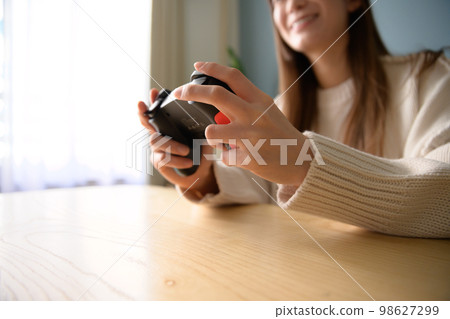 Woman playing games in the living room, game girl, game controller, lifestyle, new normal, natural light 98627299