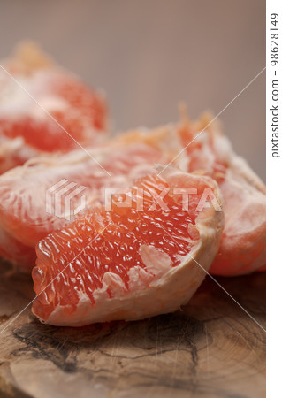 Peeled grapefruit on olive serving board Peeled grapefruit on olive serving board 98628149