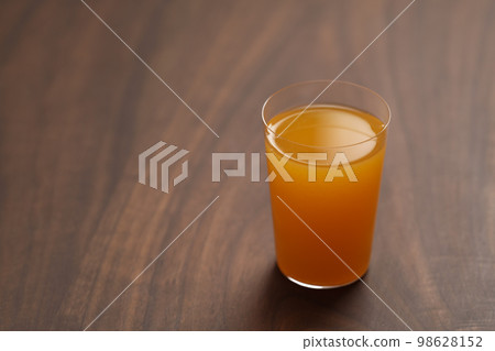 Fresh orange juice in thin glass on wooden table with copy space 98628152