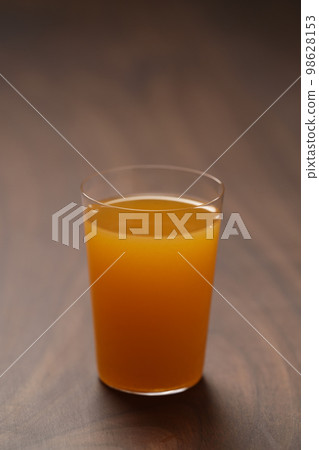 Fresh orange juice in thin glass on wooden table with copy space Fresh orange juice in thin glass on wooden table with copy space 98628153