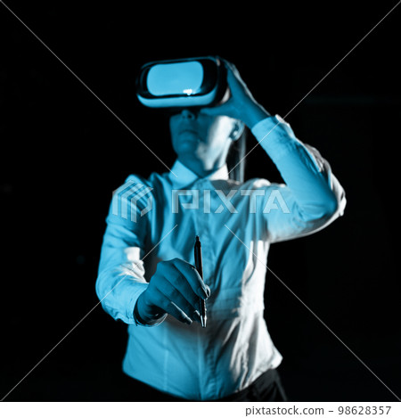 Woman Wearing Vr Glasses And Writing On Important Messages With pen. Businesswoman Having Virtual Reality Eyeglasses And Showing Crutial Informations. 98628357