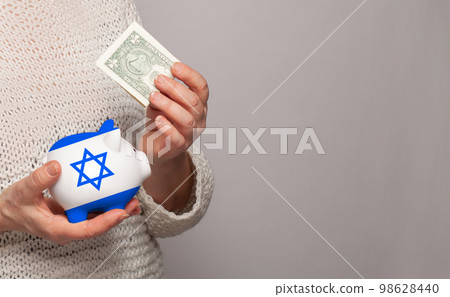Flag of Izrael on money bank in Izraeli woman hands. Flag of Izrael on money bank in Izraeli woman hands. 98628440