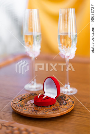wedding rings on a background of glasses of champagne wedding rings on a background of glasses of champagne 98628727