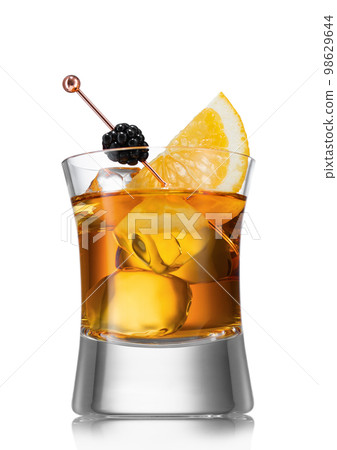 Old fashioned cocktail with ice cubes and blackberry with orange slice on white background. Old fashioned cocktail with ice cubes and blackberry with orange slice on white background. 98629644