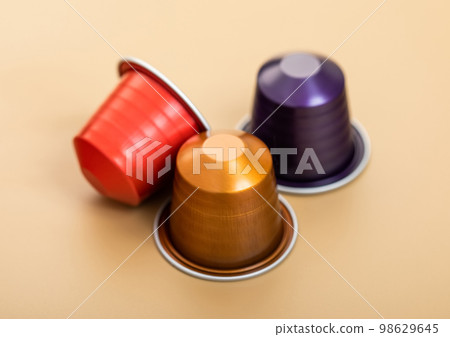 Three aluminium coffee capsules pods on beige background.Macro Three aluminium coffee capsules pods on beige background.Macro 98629645