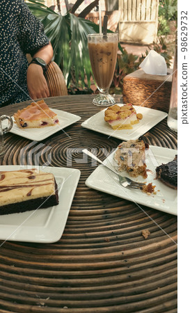Vertical shot of eating traditional german Christmas stollen cake or Christstollen and other cakes together at a cafe Vertical shot of eating traditional german Christmas stollen cake or Christstollen and other cakes together at a cafe 98629732