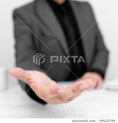 Businessman in Grey jacket Holding Important Message In One Hand. Man In Suit Showing New Crutial Idea In Palm. Executive Presenting Updated Critical Information. Businessman in Grey jacket Holding Important Message In One Hand. Man In Suit Showing New Crutial Idea In Palm. Executive Presenting Updated Critical Information. 98629799