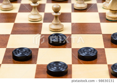 pawn and checkers piece in center of board closeup pawn and checkers piece in center of board closeup 98630131