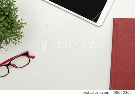 Office Supplies Over Desk With Keyboard And Glasses And Coffee Cup For Working Remotely, Assorted School Utilities For Studying With Hot Drink And Eyeglasses. 98630363
