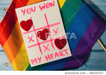 Handmade valentine with Text YOU WON MY HEART and tic tac toe game red envelope and LGBTQ flag. Gift idea with your own hands. Handmade valentine with Text YOU WON MY HEART and tic tac toe game red envelope and LGBTQ flag. Gift idea with your own hands. 98630507