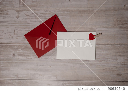 Greeting or invitation card mock up with red envelope on wooden background. Romantic Small hearts Valentine day. Blank paper card copy space for your text. Holiday morning Greeting or invitation card mock up with red envelope on wooden background. Romantic Small hearts Valentine day. Blank paper card copy space for your text. Holiday morning 98630540