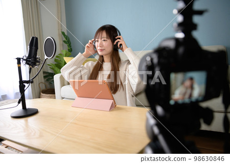 Single-lens reflex video shooting, woman delivering with tablet and microphone, video shooting, game commentary, YouTuber 98630846