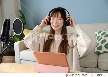 Single-lens reflex video shooting, woman delivering with tablet and microphone, video shooting, game commentary, YouTuber 98630930