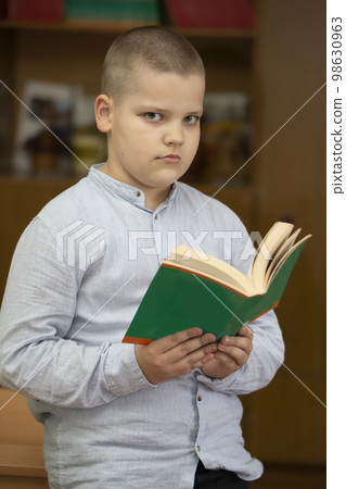Schoolboy, middle school student with a book. 98630963