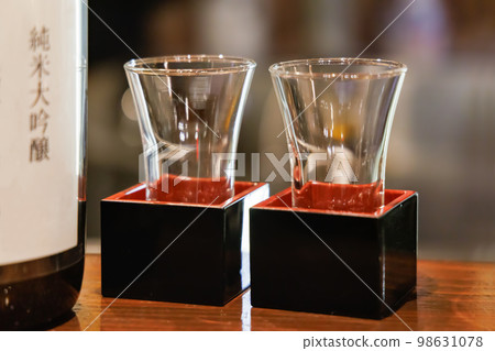 Sake that looks delicious and a glass for pouring 98631078