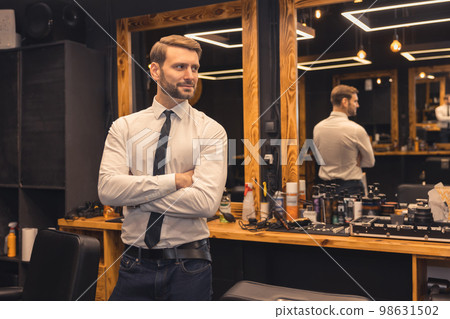Good-looking confident businessman in a barbershop Good-looking confident businessman in a barbershop 98631502