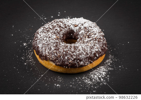 Sprinkling sugar powder on chocolate donut Sprinkling sugar powder on chocolate donut 98632226