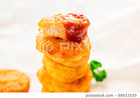 Stacked chicken nuggets with ketchup Stacked chicken nuggets with ketchup 98632830