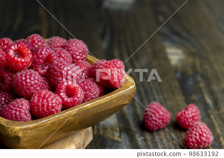 The harvest of red ripe raspberries is on the board The harvest of red ripe raspberries is on the board 98633192