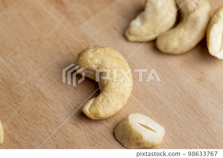 a few raw cashew nuts on the board 98633767
