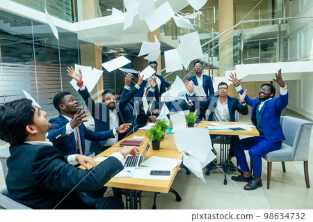 international group of nine african american and indian people having fun and throwing paper up after brain storm in big office international group of nine african american and indian people having fun and throwing paper up after brain storm in big office 98634732