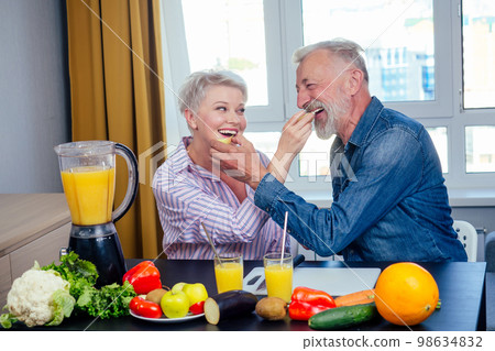 Senior couple drinking vegan smoothie with organic fruits and vegatables from eco glasses and reusable tubes 98634832