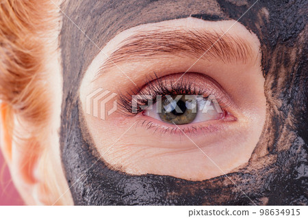 redhaired ginger young caucasian woman with natural anti acne mask on her pretty perfect face in studio pink background 98634915