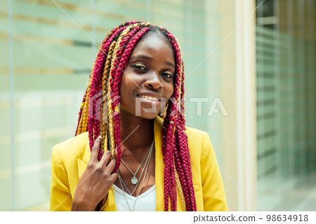 creative stylist african american young woman with kanekalon hair long afro-braids in a yellow jacket. beautiful clothes designer dressmaker posing in craft workplase office 98634918