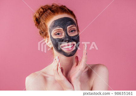 redhaired ginger young caucasian woman with natural anti acne mask on her pretty perfect face in studio pink background 98635161