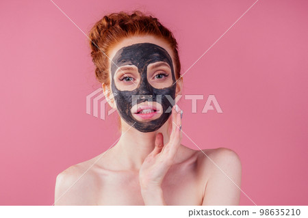 redhaired ginger young caucasian woman with natural anti acne mask on her pretty perfect face in studio pink background redhaired ginger young caucasian woman with natural anti acne mask on her pretty perfect face in studio pink background 98635210