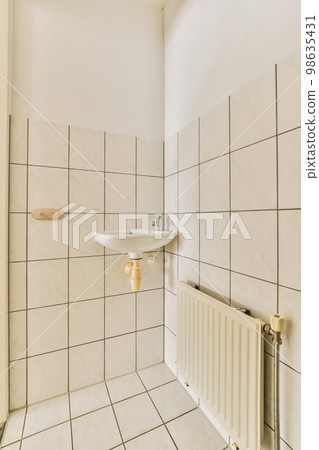 a bathroom with white tiles and black lines on the walls, along with a sink in the corner of the room 98635431