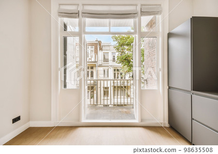 an empty kitchen with the door open to reveal a view into the yard and courtyards in the apartment's backyard an empty kitchen with the door open to reveal a view into the yard and courtyards in the apartment's backyard 98635508