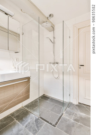 a bathroom with a sink, mirror and shower head mounted on the wall next to the bathtub that's attached to the 98635582