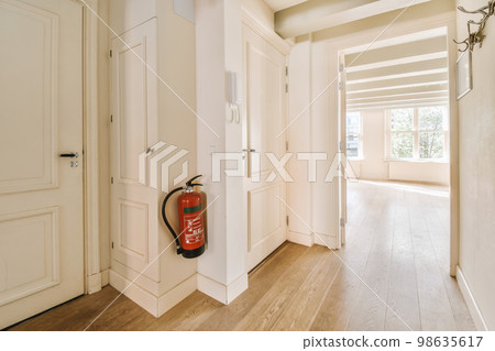 an empty room with a fire exor in the door and a red can on the floor next to it an empty room with a fire exor in the door and a red can on the floor next to it 98635617