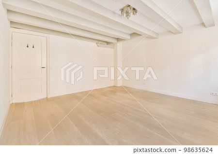 an empty room with white walls and wood flooring on either side of the room, there is a door that leads to another 98635624
