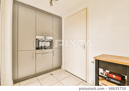 a kitchen area with an oven, microwave and toaster on the floor in front of the door to the room 98635738