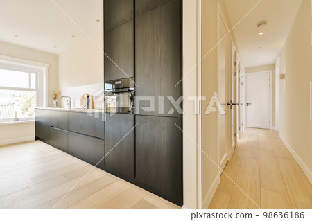 a kitchen and dining area in a new home with wood flooring, white walls and black cabinetd cupboards a kitchen and dining area in a new home with wood flooring, white walls and black cabinetd cupboards 98636186