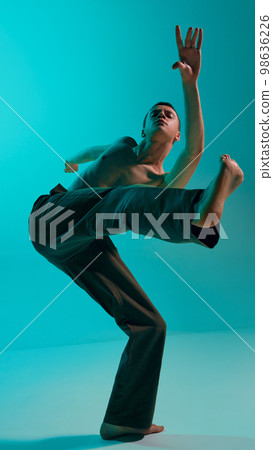 Contemporary dance style. Young, artistic, flexible shirtless man dancing over blue, cyan studio background. Experimental dance Contemporary dance style. Young, artistic, flexible shirtless man dancing over blue, cyan studio background. Experimental dance 98636226