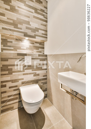 a white toilet in a bathroom with tile on the walls and wall behind it is a sink that has been installed a white toilet in a bathroom with tile on the walls and wall behind it is a sink that has been installed 98636227