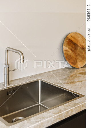 a kitchen sink with a wooden cutting board on the wall above it and a round mirror in the corner next to the sink a kitchen sink with a wooden cutting board on the wall above it and a round mirror in the corner next to the sink 98636341
