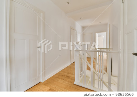 an empty room with white walls and wood flooring in the center of the room, there is a mirror on the wall 98636566