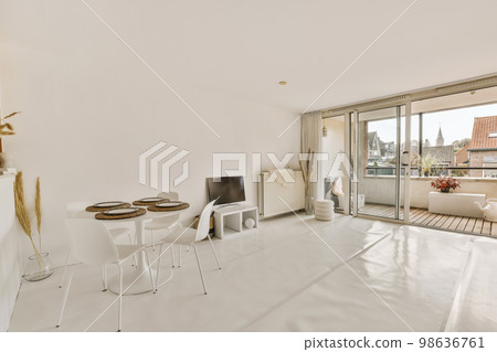 a living room with white furniture and large sliding glass doors that open onto the balcony overlooking the cityscale a living room with white furniture and large sliding glass doors that open onto the balcony overlooking the cityscale 98636761