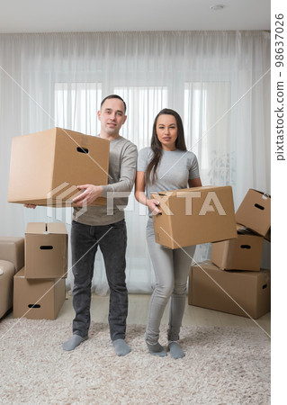 Happy couple having fun with cardboard boxes in new house on moving day Happy couple having fun with cardboard boxes in new house on moving day 98637026