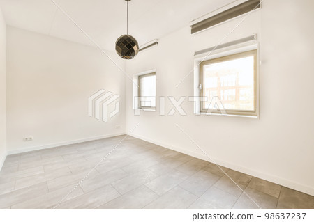 an empty room with white walls and wood flooring, there is a large window that looks out onto the street 98637237
