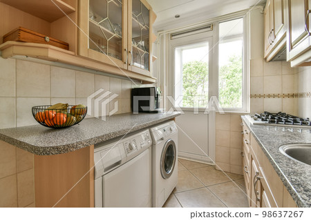 a kitchen area with a sink, stove and dishwasher on the counter in front of the washer a kitchen area with a sink, stove and dishwasher on the counter in front of the washer 98637267