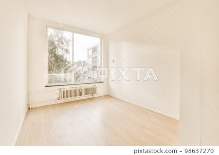 an empty room with white walls and wood flooring on the right, there is a large window to the left 98637270