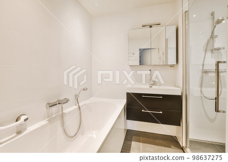 a bathroom with a bathtub and shower stall in the corner next to the tub, there is a mirror on the wall a bathroom with a bathtub and shower stall in the corner next to the tub, there is a mirror on the wall 98637275